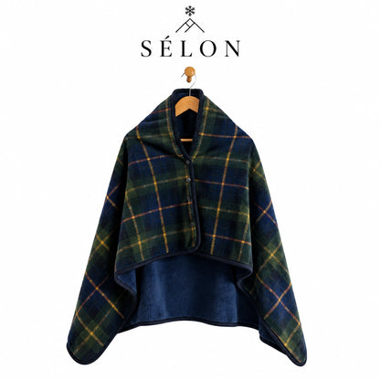 Green and navy tartan flannel shawl hanging on a wooden hanger